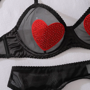 Close-up of black mesh lingerie with red sequin heart detail and satin trimming