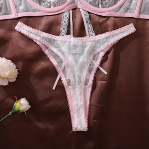Détail de dentelle de cils rose et blanche sur string pour femme en maille fine