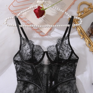 Detailed close-up of a black floral lace bodysuit with underwire cups and mesh panelling