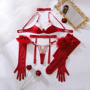 Flat lay of red lingerie set with feather gloves, stockings, and satin bow details