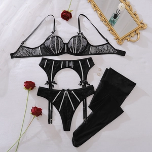 Detail van zwarte kanten lingerieset met zilveren glitterbandjes en strikversiering