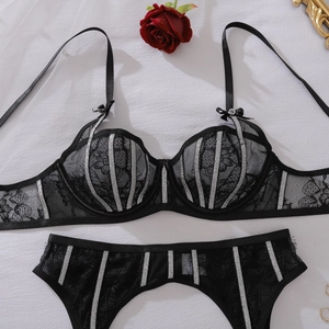 Zwarte kant lingerie set met zilveren glitterstrepen en rode roos decor op witte achtergrond