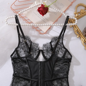 Close-up of black eyelash lace lingerie with fishbone corset details and red roses