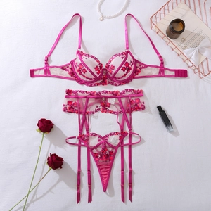 Flat lay of magenta floral embroidery lace lingerie set with bra, garter and thong