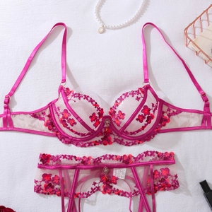 Flat lay of rose red floral embroidered lace lingerie set with garters on white background