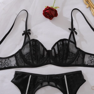 Gedetailleerde weergave van zwarte kanten lingerieset met zilveren glitterbandjes en bloemengaas