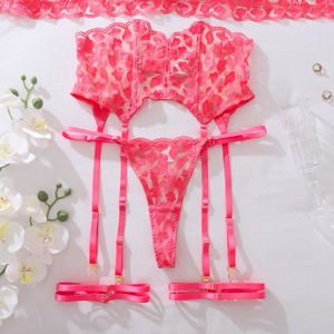Flat lay of rose pink lace lingerie set with heart patterns and gold hardware detail