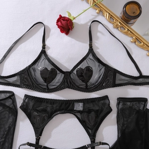 Détail d'un ensemble de lingerie en tulle avec cœurs en simili cuir et bas résille