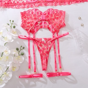 Detail view of pink lace lingerie set with heart embroidery and gold garter buckles