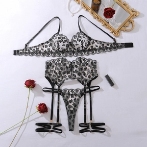 Detail of leopard print lace lingerie set with garters and pearls on a white surface