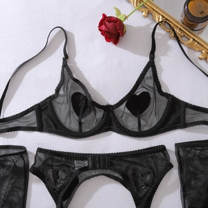 Détail de l'ensemble de lingerie en mesh avec patchs cœur noirs et porte-jarretelles
