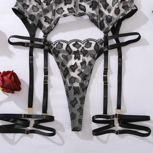 Detail of leopard lace garter belt set with gold buckles and sheer mesh texture