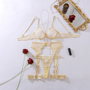 Detail of sheer yellow floral lace lingerie set with elegant gold metal body chain