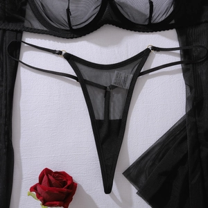 Détail de lingerie en maille noire transparente avec anneaux dorés et dentelle