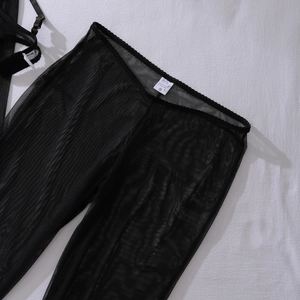 Vue détaillée du pantalon en résille noire avec étiquette 95% polyester et taille élastique