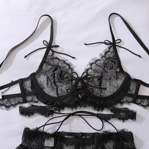Détail à plat d'un ensemble de lingerie en dentelle noire avec petits nœuds