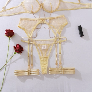 Detailed flat lay of bright yellow lace lingerie set with decorative gold metal chains