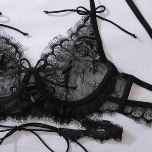 Gros plan sur un soutien-gorge en dentelle noire avec nœud et broderie florale