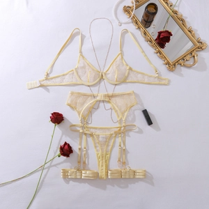 Flat lay of yellow lace lingerie set with metal body chain and decorative roses