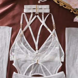 Detail of white mesh lace lingerie set with gold buckles on red satin backdrop