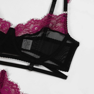 Close-up of pink floral lace and black sheer mesh fabric on sexy four-piece lingerie