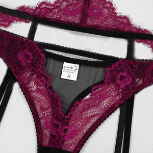Detailed macro view of purple floral lace and black mesh fabric with a garment care label