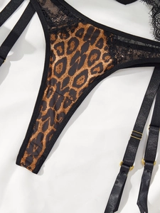 Détails d'un ensemble string et porte-jarretelles en dentelle léopard et boucles dorées