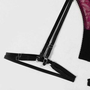 Detail of black elastic garter straps with silver metal adjusters and red lace mesh