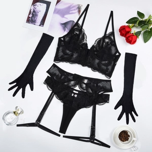 Flat lay of black lace lingerie set with mesh embroidery, garters and long gloves