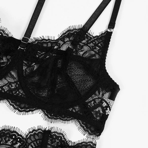 Détail d'un soutien-gorge en dentelle noire avec motifs en résille et bords cil