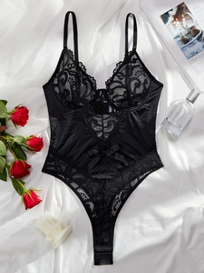 Flat lay of black lace and satin bodysuit with floral embroidery and bow detail