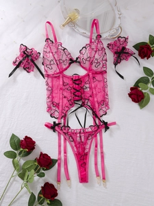 Detail of rose red lace lingerie set with heart embroidery and black ribbon ties