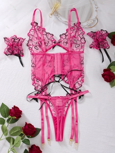 Flat lay of pink lace lingerie set with heart embroidery and floral decor