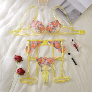 Detail of floral embroidery on yellow lace bra with garter belt and matching thong