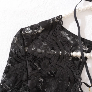 Détail d'un body en dentelle noire avec broderie florale complexe et fines bretelles chic