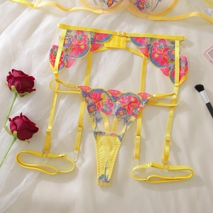 Detail of yellow lace lingerie with pink floral embroidery and adjustable garters
