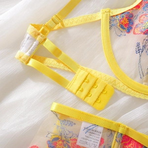 Close-up of yellow floral embroidery, adjustable straps and triple hook-and-eye closure