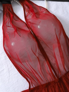 Detail view of red sheer mesh bodysuit featuring halter neck and elastic pleated waist