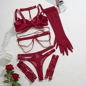 Ensemble lingerie bordeaux détaillé avec chaînes dorées et gants en tulle fin