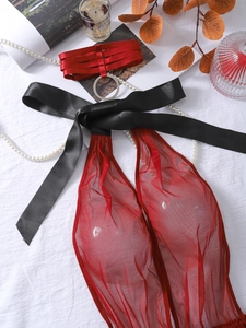 Detail of red mesh bodysuit featuring satin neck collar with metal ring and black bows