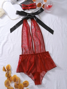 Close-up of red mesh bodysuit featuring a deep V-neck and large black satin bow tie