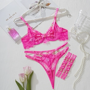 Détails d'un ensemble lingerie en dentelle rose avec anneaux dorés et lanières