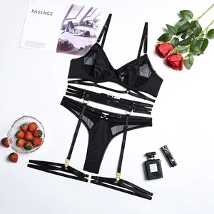 Detailed view of black lace lingerie set with gold metal adjusters on white background