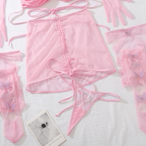 Détail à plat de l'ensemble lingerie en résille rose avec bas papillon et jupe