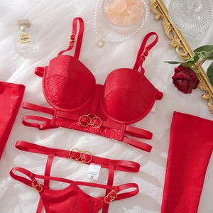 Detalle de lencería roja con efecto de serpiente, aros dorados y decoración de lujo