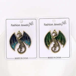 Detail of high-end enamel dragon brooches in blue and green with gold plating