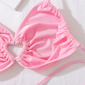 Détail d'un body en résille rose avec anneau argenté en forme de cœur et tissu plissé