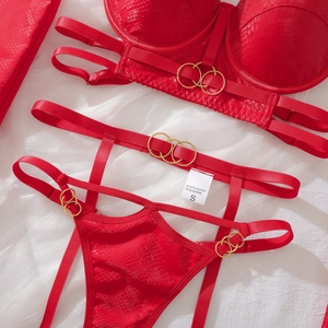 Vista detallada del conjunto de lencería roja con textura de serpiente y aros