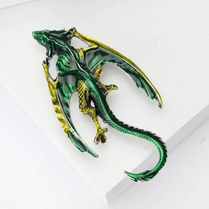 Detailed view of green and yellow enamel dragon brooch with intricate wing textures