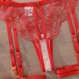 Détail d'un porte-jarretelles en dentelle rouge avec boucles en métal doré